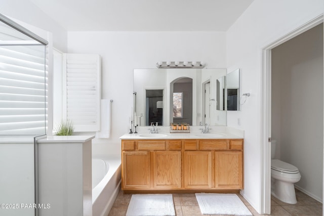 bathroom with vanity, toilet, tile patterned flooring, and a bathtub