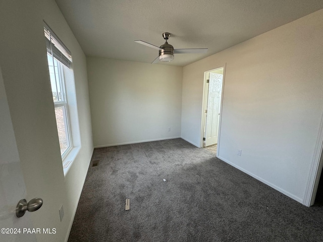 carpeted empty room with ceiling fan and a healthy amount of sunlight