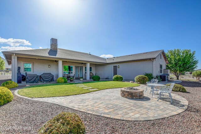9150 N Whitney Way, Prescott Valley, AZ 86315 - back of property featuring ceiling fan, stucco siding, a fire pit, a patio area, and a yard