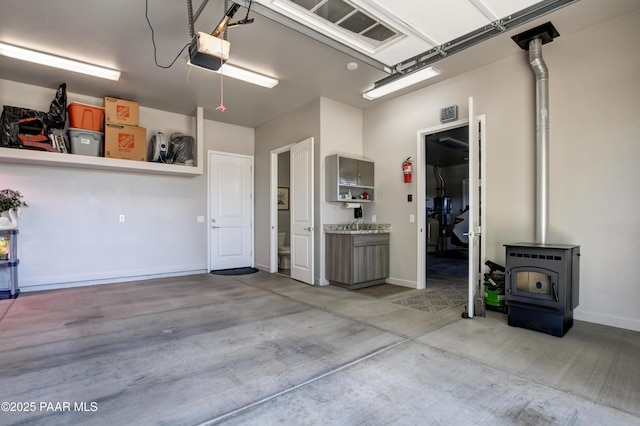 9150 N Whitney Way, Prescott Valley, AZ 86315 - garage featuring a garage door opener, a wood stove, and baseboards