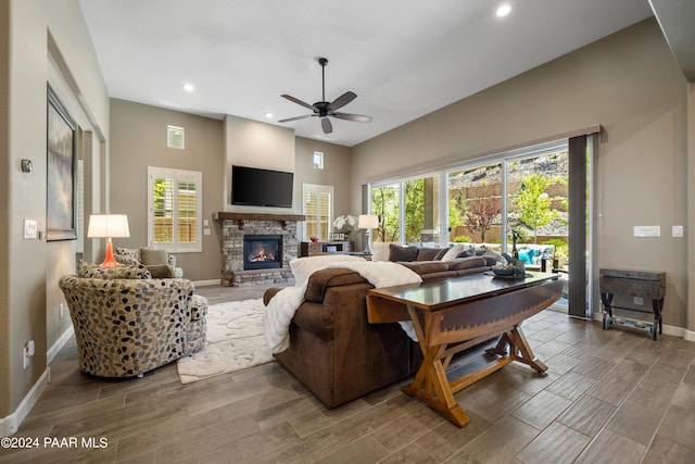 living room featuring a fireplace, hardwood / wood-style floors, and ceiling fan