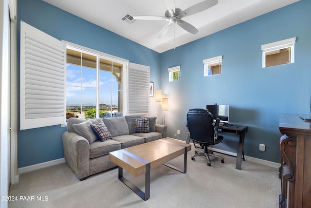 carpeted home office featuring ceiling fan