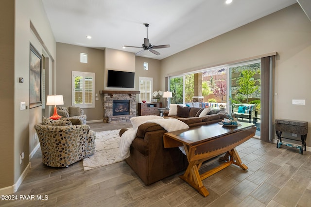 living room with ceiling fan, light wood-type flooring, and a fireplace