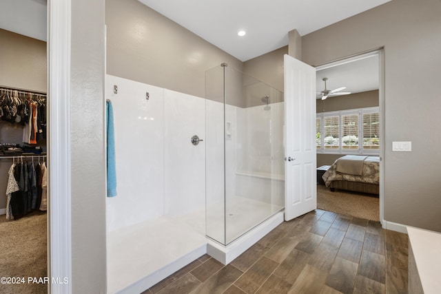 bathroom featuring ceiling fan, wood-type flooring, and walk in shower