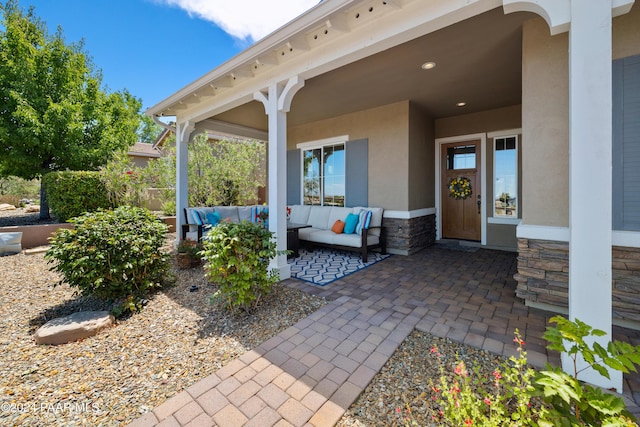 entrance to property with an outdoor living space and a patio area