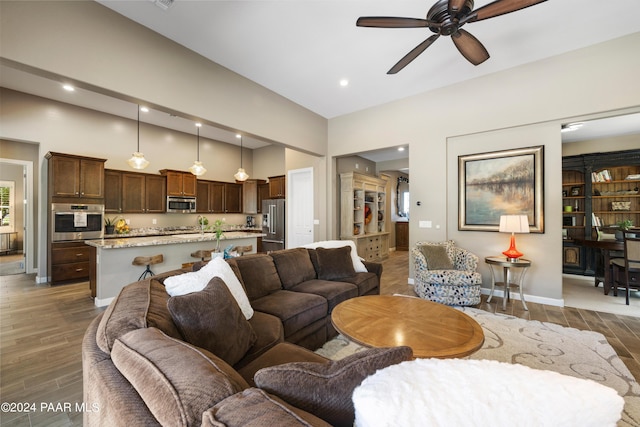 living room with ceiling fan and dark wood-type flooring