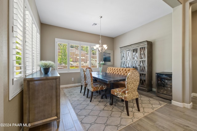 dining space featuring a chandelier, wine cooler, and light hardwood / wood-style flooring