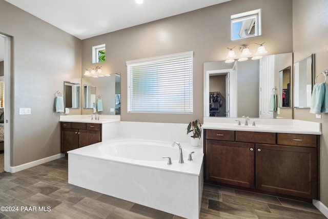 bathroom with vanity, wood-type flooring, and a tub to relax in