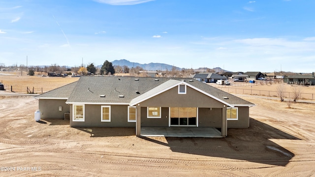 rear view of house with a mountain view and a patio