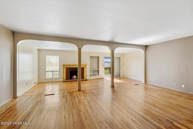 2403 Country Park Dr, Prescott, AZ 86305 - unfurnished living room with arched walkways, light wood-style flooring, and a fireplace