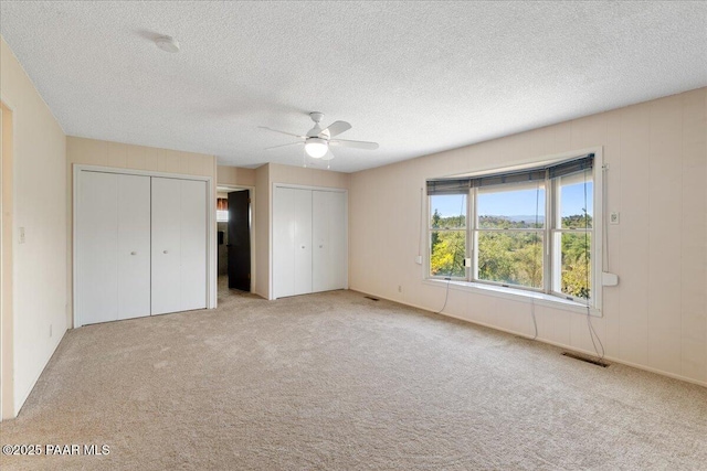 2403 Country Park Dr, Prescott, AZ 86305 - unfurnished bedroom with multiple closets, carpet flooring, a textured ceiling, and a ceiling fan
