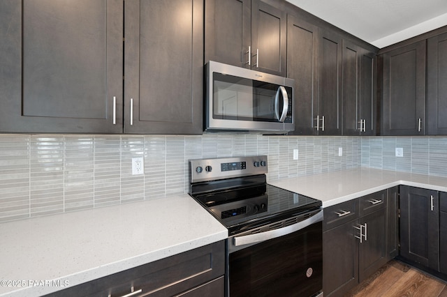 kitchen with tasteful backsplash, dark brown cabinets, stainless steel appliances, and light hardwood / wood-style flooring