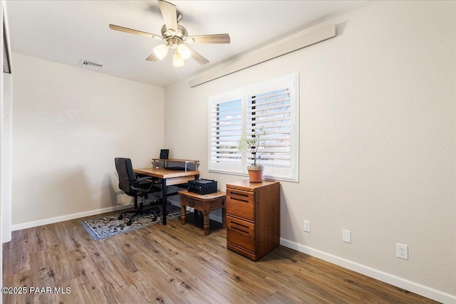 office featuring visible vents, baseboards, ceiling fan, and wood finished floors