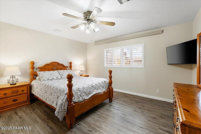 bedroom featuring ceiling fan, wood finished floors, visible vents, and baseboards