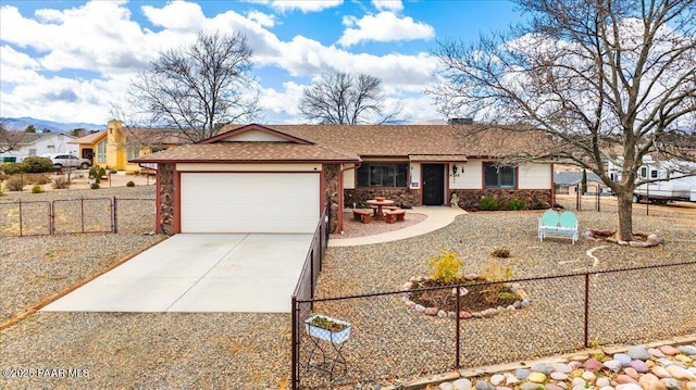 ranch-style home featuring concrete driveway, stone siding, an attached garage, and fence