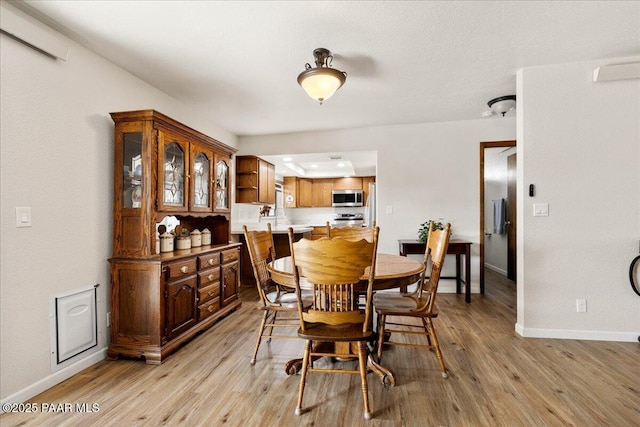 dining room featuring light wood-type flooring and baseboards