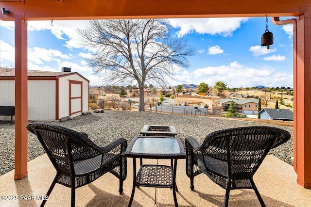 view of patio / terrace with a storage shed, an outdoor structure, and fence