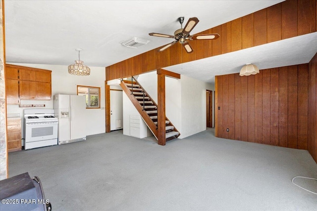 1485 S Pima Rd, Dewey-Humboldt, AZ 86327 - unfurnished living room with wooden walls, carpet flooring, stairway, and ceiling fan