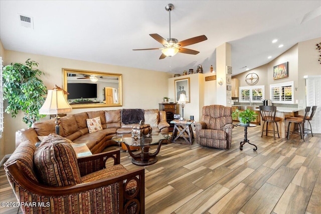 living room with ceiling fan and vaulted ceiling