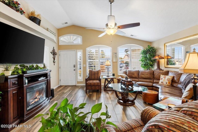 living room featuring light wood-type flooring, vaulted ceiling, plenty of natural light, and ceiling fan