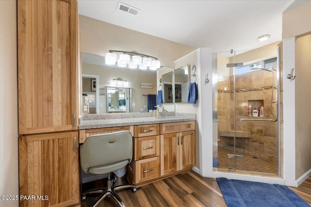 bathroom featuring vanity, hardwood / wood-style flooring, and walk in shower