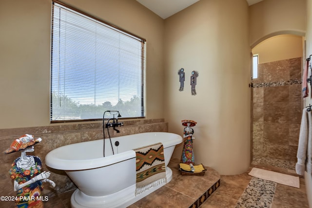 full bathroom with tile walls, a soaking tub, a tile shower, a wainscoted wall, and tile patterned flooring