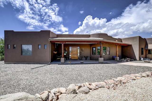 rear view of property with a patio and stucco siding