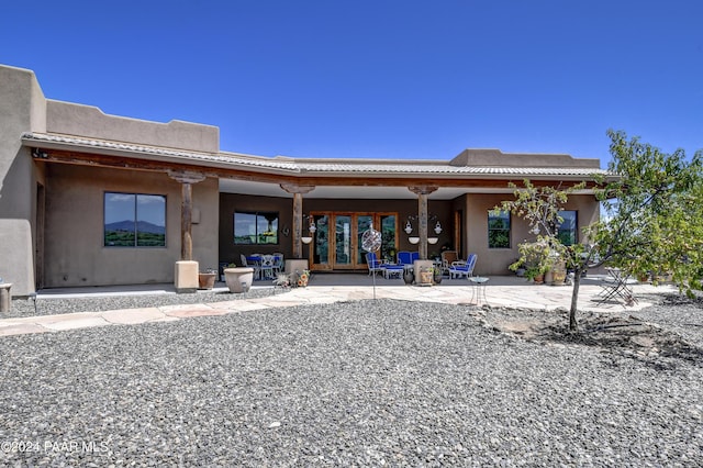 back of property with a patio and stucco siding