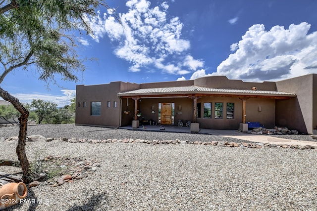 rear view of house featuring a patio and stucco siding