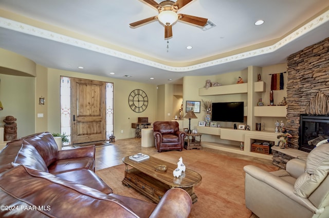 living area with a ceiling fan, recessed lighting, and a stone fireplace