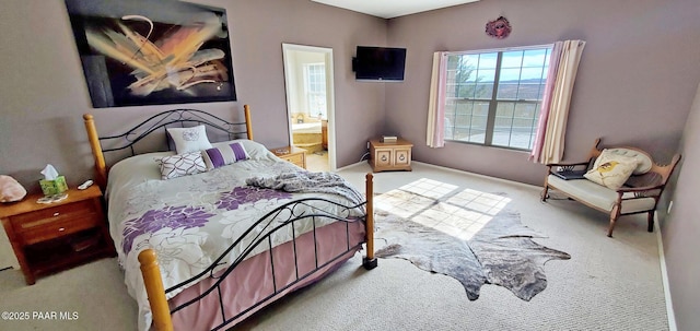 bedroom featuring connected bathroom and carpet