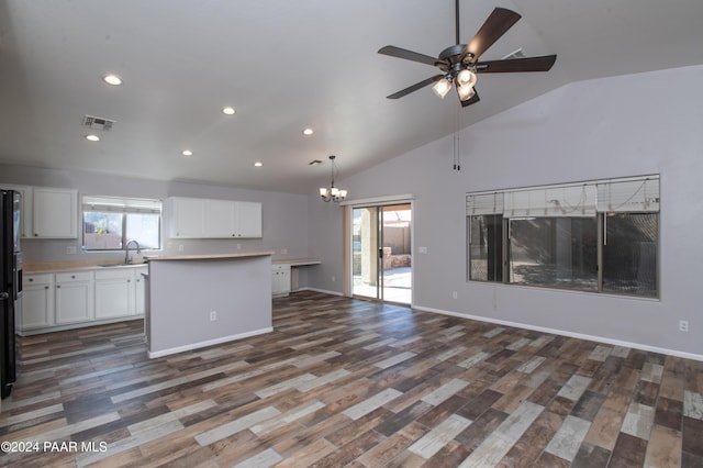 interior space with ceiling fan with notable chandelier, high vaulted ceiling, dark wood-type flooring, and sink