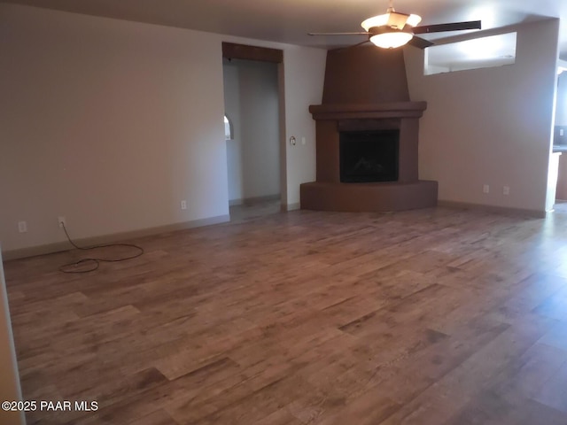 3575 N Meadowlark Dr, Prescott Valley, AZ 86314 - unfurnished living room with ceiling fan, wood finished floors, a large fireplace, and baseboards
