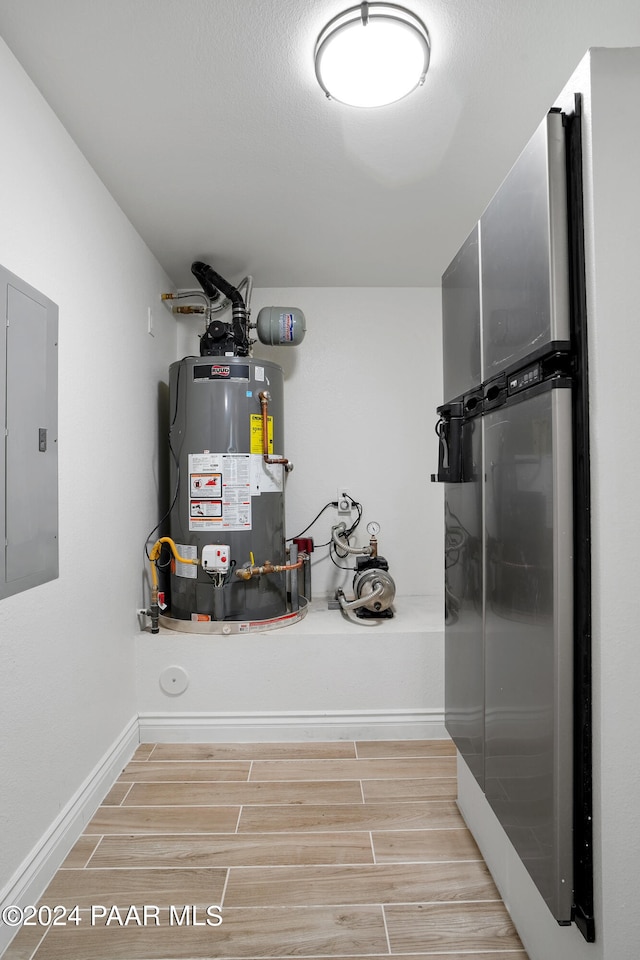 utility room featuring electric panel and gas water heater