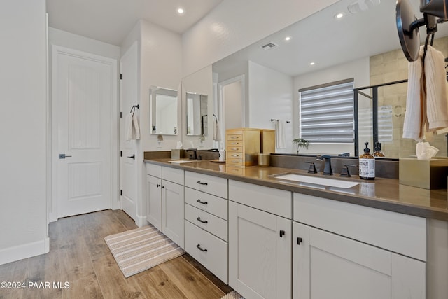 bathroom with a shower with door, vanity, and hardwood / wood-style flooring