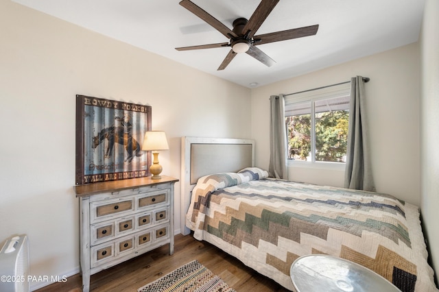 bedroom featuring a ceiling fan, wood finished floors, and baseboards