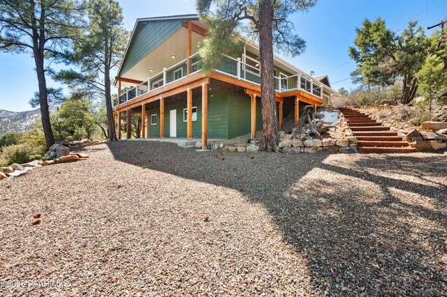 back of property featuring stairway and a wooden deck