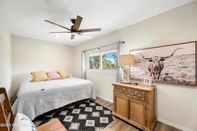 bedroom featuring light wood finished floors, ceiling fan, and baseboards