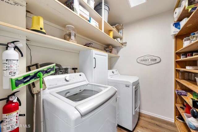 washroom featuring laundry area, light wood-style flooring, washing machine and dryer, and baseboards