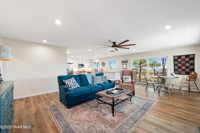 living room with recessed lighting, baseboards, a ceiling fan, and light wood finished floors