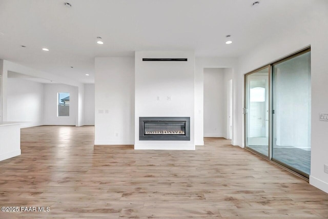 3263 Iron King Cir, Prescott, AZ 86301 - unfurnished living room featuring light wood-type flooring, a glass covered fireplace, recessed lighting, and baseboards