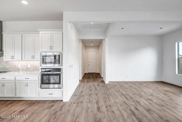 3263 Iron King Cir, Prescott, AZ 86301 - kitchen with appliances with stainless steel finishes, light wood-style floors, white cabinets, decorative backsplash, and baseboards
