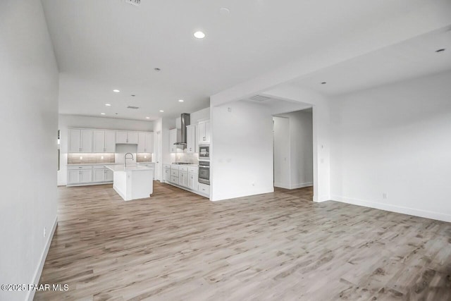 3263 Iron King Cir, Prescott, AZ 86301 - kitchen with open floor plan, wall chimney exhaust hood, light wood finished floors, and recessed lighting
