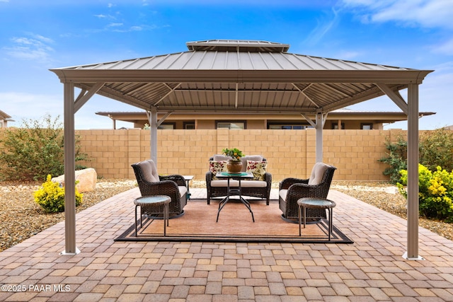 view of patio featuring a gazebo, an outdoor hangout area, and fence