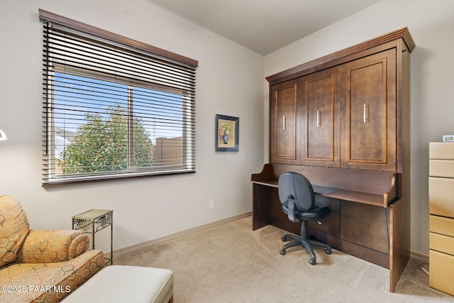 home office with baseboards and light carpet