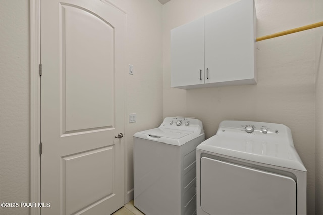 laundry area featuring washer and clothes dryer and cabinets