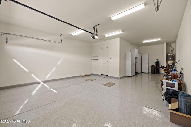 garage featuring baseboards, gas water heater, and a garage door opener