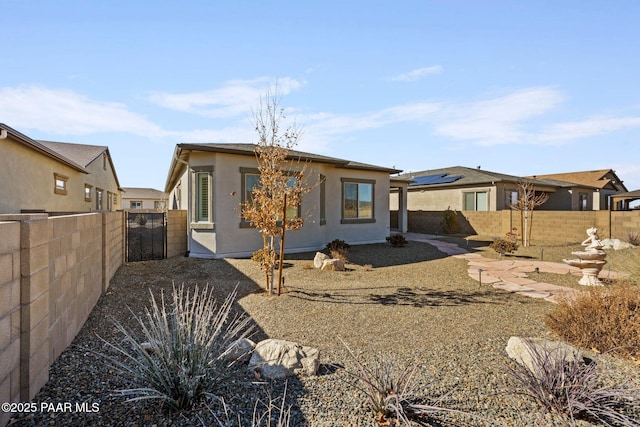 back of property featuring a fenced backyard and stucco siding