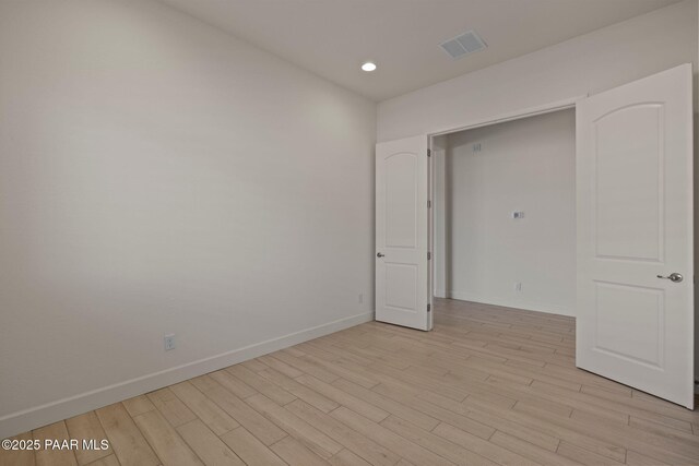 interior space featuring light wood-style floors, a notable chandelier, and baseboards