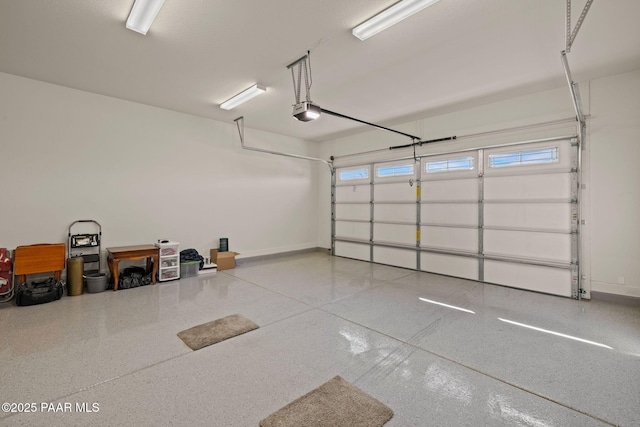 garage with a garage door opener and baseboards